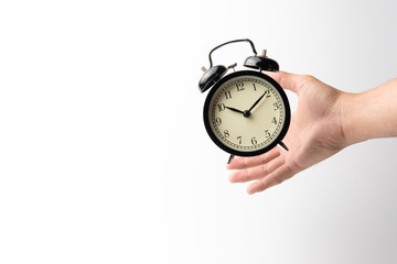 grab the black retro alarm clock flying on the air with men's hand on white background