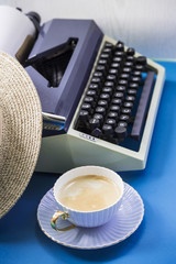 Wall Mural - Typewriter next to a straw hat and a cup of coffee