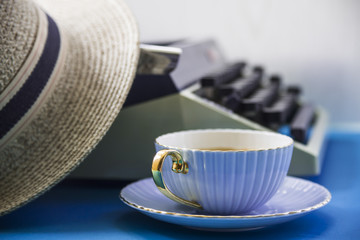 Wall Mural - Typewriter next to a straw hat and a cup of coffee