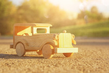 Old Wooden Toy Car On The Road Outdoors In The Park At Sunset