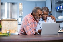 Smiling Couple Using Laptop Computer