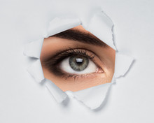 Female Eye In Paper Hole