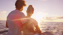 Cruise Ship Vacation Couple Enjoying Sunset View Sailing On Small Cruise Boat At Sea. Romantic Couple On Honeymoon Travel At Sea Looking At Sunset. RED EPIC SLOW MOTION.