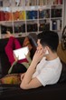 © Wavebreak Media - Man talking on mobile phone while woman using digital tablet on sofa
