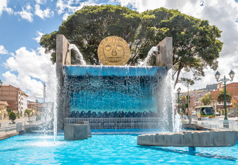 Wall Mural - Water fountain monument with Golden Inca Sun Disc in the streets of Cusco City - Cusco, Peru