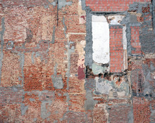 Part Of Old Derelict Brick Wall With Several Different Bricks And Cement Patches