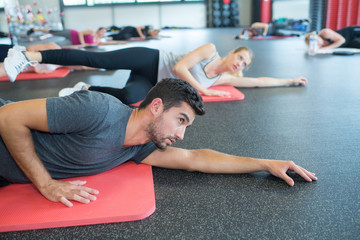 group of people laying over mats in gym