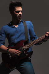 Poster - passionate young guitarist playing his electric guitar