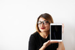 © shurkin_son - Attractive and confident female entrepreneur in eyewear having cunning look while promoting her product, holding digital tablet with copy space screen for your text or advertising information