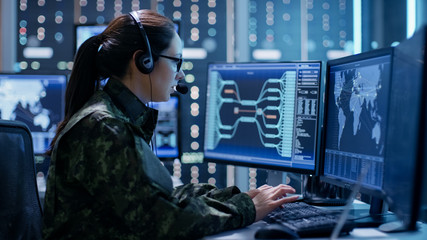 Aufkleber - Shot of Female Government Agent Tracking Fugitive with Her Computer in Big Monitoring Room Full of Computers with Animated Screens.