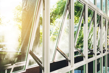 Modern office building wall and opened window in the morning, with bright sunlight