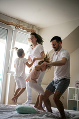 Wall Mural - Happy family having fun on bed.