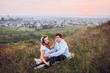 © nataliakabliuk - couple, love, nature and people concept - happy loving couple sitting on a plaid in a field on a background of magical sunset