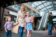 © LIGHTFIELD STUDIOS - happy children with mother walking with shopping bags at shopping mall
