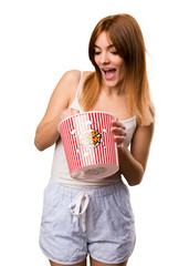 Wall Mural - Beautiful girl in pajamas eating popcorns