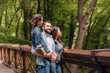 © LIGHTFIELD STUDIOS - Young happy interracial family standing on wooden bridge, while father holding his daughter in arms