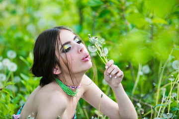 Wall Mural - girl with fashionable makeup and beads in green leaves