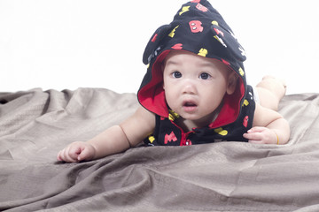 cute baby boy laying children,s rug on white background