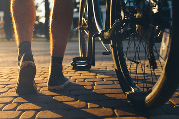 Poster - Closeup Of Male Feet And City Bicycle Wheels, Rear View And Low Angle Holiday Weekend Activity