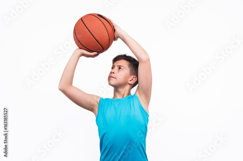 Plakat Młoda chłopiec bawić się koszykówkę odizolowywającą na bielu