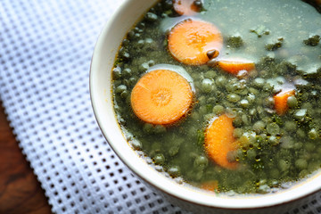 Bowl with tasty lentil dish on kitchen table, closeup