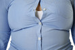Diet concept. Overweight woman in tight shirt, closeup