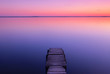 Landscape on the lake after sunset with a wooden pier on a long exposure