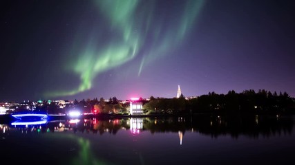 Wall Mural - aurora borealis over reykjavik city pond water reflection realistic 4k