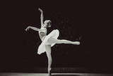 Young ballerina in ballet costume dancing in city park, on stairs feeling breath of big city life and freedom