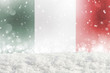 Defocused Italy flag as a winter Christmas background with falling snow, snowdrift and bokeh