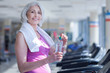 © zinkevych - Senior woman with towel and water at gym