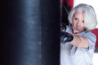 © zinkevych - Closeup of serious aged woman boxing punchbag