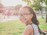 Fototapeta Desenie - Happy little girl wear glasses riding bike in the park,she is enjoying bike ride and smilling.On the sunny day.