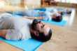 © Syda Productions - man with group of people doing yoga at studio