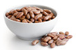 Dry pinto beans in white ceramic bowl isolated on white. Spilled beans.