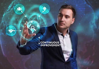 Business, Technology, Internet and network concept. Young businessman working on a virtual screen of the future and sees the inscription: Continuous improvement