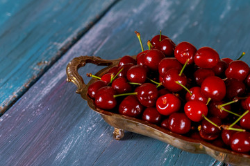 Detail of ripe red cherries on a wooden board. Harvested sweet cherries.