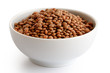 Dry unpeeled red lentils in white ceramic bowl isolated on white.