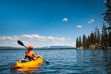 woman kayaking on lake jenny in grand tetons national park