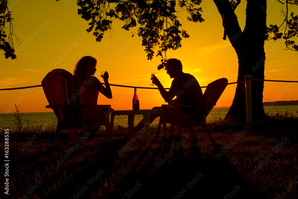 couple drinking wine against sunset as silhouette