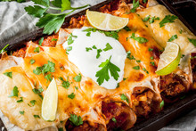 Mexican Food. Cuisine Of South America. Traditional Dish Of Spicy Beef Enchiladas With Corn, Beans, Tomato. On A Baking Tray, On Old Rustic Wooden Background. Close View