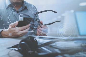 Poster - cyber security internet and networking concept.Businessman hand working with VR screen padlock icon mobile phone on computer background