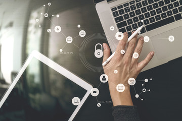 Poster - cyber security internet and networking concept.Businessman hand working with VR screen padlock icon on laptop and digital tablet computer