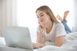 © Africa Studio - Pretty young girl lying on bed and using laptop in room