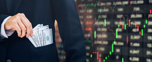 Businessman Holding money US dollar bills Business Financial concept Forex graph of stock market on background