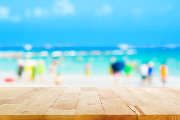 Wall Mural - Wood table top with blurred people at the beach as background - can be used for display or montage your products