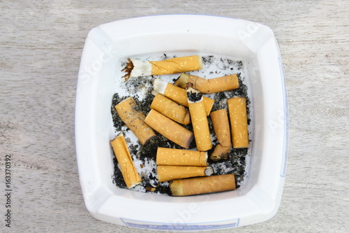 Fotografie, Obraz mégots de cigarettes dans cendrier,fond bois