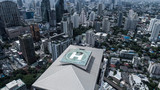 Aerial drone view of helipad isolated on top of the skycraper in Bangkok city during cloudy day