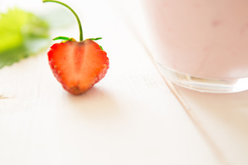 Strawberry close-up on rustic wooden table with yoghurt