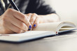 © Robert Przybysz - Kobieta pisze w kalendarzu. Kobieta zapisuje w kalendarzu notatkę